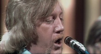 Movie still from “24 Hour Party People” (2002), directed by Tom Bruggen – A person with a microphone; Extreme Close Up shot, Low angle