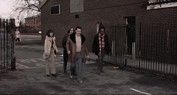 Movie still from “24 Hour Party People” (2002), directed by Tom Bruggen – A group of people walking down a street; Wide shot, Low angle