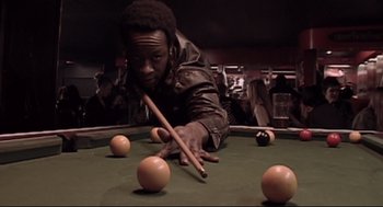 Movie still from “24 Hour Party People” (2002), directed by Tom Bruggen – A man is playing pool on a pool table; Medium shot, Low angle