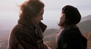 Movie still from “24 Hour Party People” (2002), directed by Tom Bruggen – Two people standing on top of a hill looking at each other; Medium shot, Low angle
