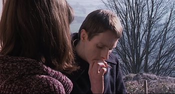 Movie still from “24 Hour Party People” (2002), directed by Tom Bruggen – A man and a woman are smoking a cigarette outside; Close Up shot, High angle