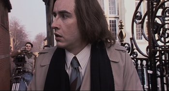 Movie still from “24 Hour Party People” (2002), directed by Tom Bruggen – A person with long hair wearing a coat; Close Up shot, Low angle