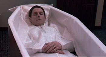 Movie still from “24 Hour Party People” (2002), directed by Tom Bruggen – A man laying in a bed wearing a white robe; Medium shot, High angle