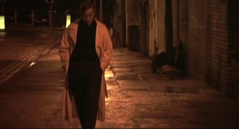 Movie still from “24 Hour Party People” (2002), directed by Tom Bruggen – A woman walking down a street at night; Wide shot, Low angle