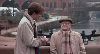 Movie still from “24 Hour Party People” (2002), directed by Tom Bruggen – A man and an old man standing next to each other; Medium shot, Over the shoulder angle