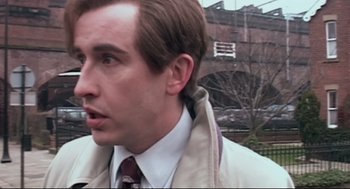 Movie still from “24 Hour Party People” (2002), directed by Tom Bruggen – A person wearing a suit and tie; Close Up shot, High angle