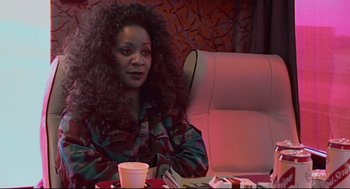 Movie still from “24 Hour Party People” (2002), directed by Tom Bruggen – A woman sitting at a table with a cup of coffee in front of her; Close Up shot, High angle