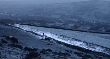 Movie still from “24 Hour Party People” (2002), directed by Tom Bruggen – A person standing on top of a snow covered slope; Extreme Wide shot, High angle