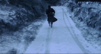 Movie still from “24 Hour Party People” (2002), directed by Tom Bruggen – A man is running down a snowy path; Extreme Wide shot, High angle