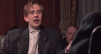 Movie still from “24 Hour Party People” (2002), directed by Tom Bruggen – A man in a black suit and a man in a white shirt; Close Up shot, Low angle
