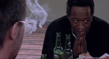 Movie still from “24 Hour Party People” (2002), directed by Tom Bruggen – A man sitting on the ground with his hands over his face; Close Up shot, Over the shoulder angle