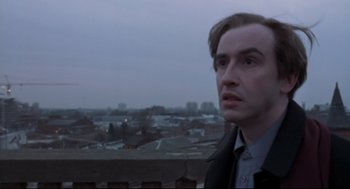 Movie still from “24 Hour Party People” (2002), directed by Tom Bruggen – A man standing on top of a building looking into the distance; Close Up shot, Low angle