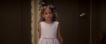 Movie still from “27 Dresses” (2008), directed by Anne Fletcher – A little girl in a white dress with a bow in her hair; Close Up shot, Over the shoulder angle
