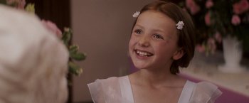 Movie still from “27 Dresses” (2008), directed by Anne Fletcher – A girl in a white dress smiling for the camera; Close Up shot, Over the shoulder angle