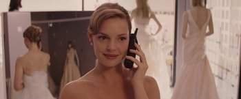 Movie still from “27 Dresses” (2008), directed by Anne Fletcher – A beautiful young woman holding a cell phone to her ear; Close Up shot, Over the shoulder angle