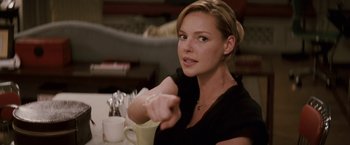 Movie still from “27 Dresses” (2008), directed by Anne Fletcher – A woman sitting at a table with a cup of coffee; Close Up shot, Over the shoulder angle
