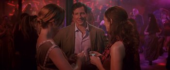 Movie still from “27 Dresses” (2008), directed by Anne Fletcher – A group of people standing around each other at a party; Medium shot, Over the shoulder angle