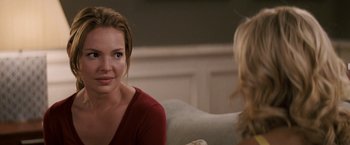 Movie still from “27 Dresses” (2008), directed by Anne Fletcher – A woman sitting in front of another woman in front of a mirror; Close Up shot, Over the shoulder angle