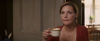 Movie still from “27 Dresses” (2008), directed by Anne Fletcher – A woman is holding a cup of coffee in her hand; Close Up shot, Over the shoulder angle
