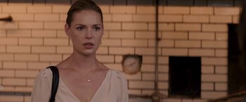 Movie still from “27 Dresses” (2008), directed by Anne Fletcher – A woman standing in front of a brick wall; Close Up shot, Over the shoulder angle