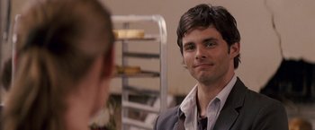 Movie still from “27 Dresses” (2008), directed by Anne Fletcher – A man in a suit and tie looking at another man in a suit and tie; Close Up shot, Over the shoulder angle
