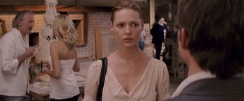 Movie still from “27 Dresses” (2008), directed by Anne Fletcher – A woman in a white shirt and a black purse; Close Up shot, Over the shoulder angle