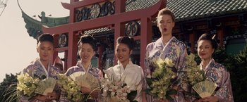 Movie still from “27 Dresses” (2008), directed by Anne Fletcher – A group of women standing next to each other holding flowers; Medium shot, Low angle