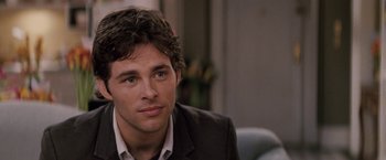 Movie still from “27 Dresses” (2008), directed by Anne Fletcher – A man in a suit sitting in front of a window; Close Up shot, Over the shoulder angle