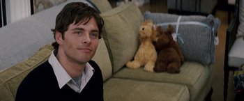 Movie still from “27 Dresses” (2008), directed by Anne Fletcher – A man sitting on a couch with stuffed animals in front of him; Close Up shot, Over the shoulder angle