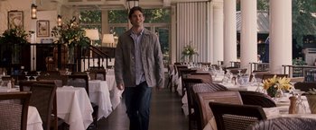 Movie still from “27 Dresses” (2008), directed by Anne Fletcher – A man walking in front of tables in a restaurant; Medium shot, Over the shoulder angle