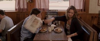 Movie still from “27 Dresses” (2008), directed by Anne Fletcher – Two people sitting at a table with plates of food on it; Medium shot, Over the shoulder angle