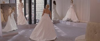 Movie still from “27 Dresses” (2008), directed by Anne Fletcher – A woman in a wedding dress looking in the mirror; Wide shot, Over the shoulder angle