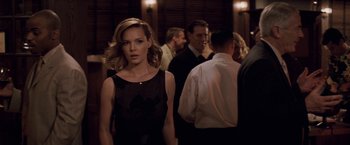 Movie still from “27 Dresses” (2008), directed by Anne Fletcher – A woman standing in front of a group of people; Medium shot, Over the shoulder angle