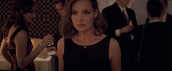 Movie still from “27 Dresses” (2008), directed by Anne Fletcher – A woman in a black dress is looking at the camera; Close Up shot, Over the shoulder angle