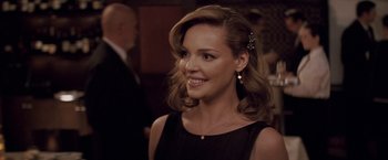 Movie still from “27 Dresses” (2008), directed by Anne Fletcher – A woman in a black dress smiling for the camera; Close Up shot, Over the shoulder angle