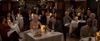 Movie still from “27 Dresses” (2008), directed by Anne Fletcher – A man and a woman sitting at a dinner table; Medium shot, High angle