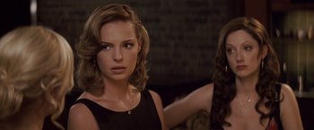 Movie still from “27 Dresses” (2008), directed by Anne Fletcher – A beautiful young lady looking at the camera while standing next to another woman; Close Up shot, Over the shoulder angle