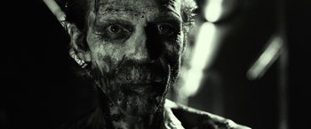 Movie still from “31” (2016), directed by Rob Zombie – A man's face in black - and - white; Close Up shot, Over the shoulder angle