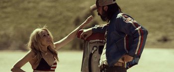 Movie still from “31” (2016), directed by Rob Zombie – A man and a woman standing next to each other on the side of the road; Medium shot, Over the shoulder angle