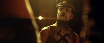 Movie still from “31” (2016), directed by Rob Zombie – A man in a military uniform and a hat; Close Up shot, Over the shoulder angle