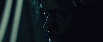 Movie still from “31” (2016), directed by Rob Zombie – A man's face in the dark; Extreme Close Up shot, Over the shoulder angle