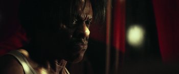 Movie still from “31” (2016), directed by Rob Zombie – An old man with a very dark face and hair; Close Up shot, Low angle