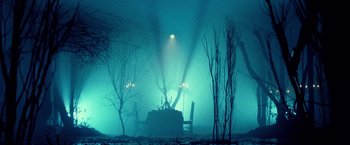 Movie still from “31” (2016), directed by Rob Zombie – A table and chairs in the middle of a foggy forest at night; Extreme Wide shot, Low angle