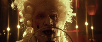 Movie still from “31” (2016), directed by Rob Zombie – An old man with white curly hair and white wig; Extreme Close Up shot, Low angle