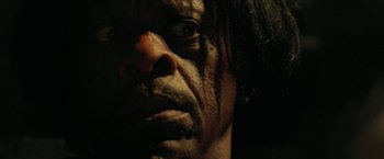 Movie still from “31” (2016), directed by Rob Zombie – The face of a man in a dark room; Extreme Close Up shot, Over the shoulder angle