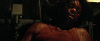 Movie still from “31” (2016), directed by Rob Zombie – A man with a bloody shirt on his chest; Close Up shot, Overhead angle