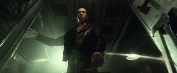 Movie still from “31” (2016), directed by Rob Zombie – A man in a leather jacket standing under a bridge; Medium shot, Low angle