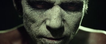 Movie still from “31” (2016), directed by Rob Zombie – The face of a man with a face full of dirt; Extreme Close Up shot, Overhead angle