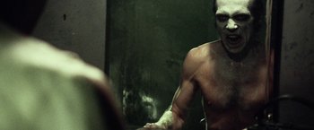Movie still from “31” (2016), directed by Rob Zombie – A man with no shirt in front of a mirror; Close Up shot, Over the shoulder angle