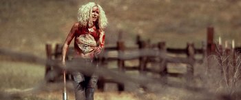 Movie still from “31” (2016), directed by Rob Zombie – A woman in a red shirt is running in the dirt; Medium shot, Low angle